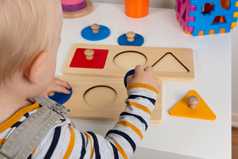 Child playing with shapes at Montessori